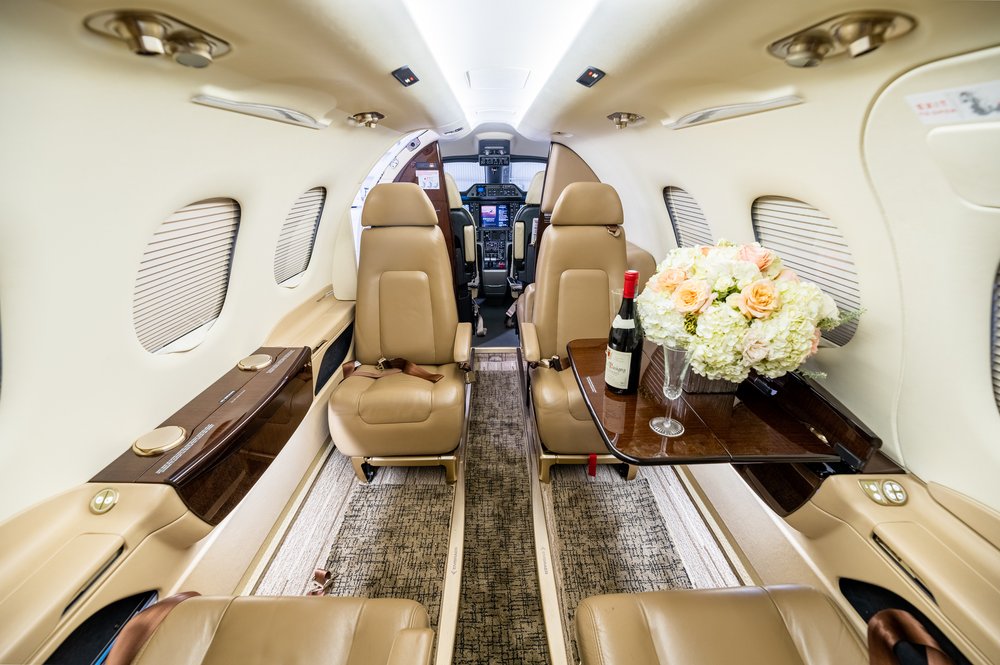Interior lujoso y confortable del Phenom 100, ideal para viajes de negocios o placer con hasta 6 pasajeros.